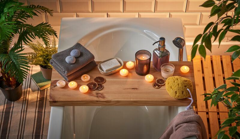 Spa bathtub wooden table vase of plant candle towel brush all kind of spa object. Modern spa center.